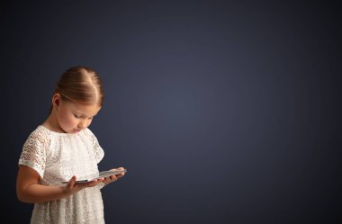 Tablet ile koyu arka plan kullanarak sevimli küçük kız