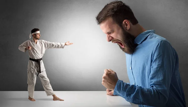 Hombre gigante gritándole a un pequeño hombre de karate —  Fotos de Stock