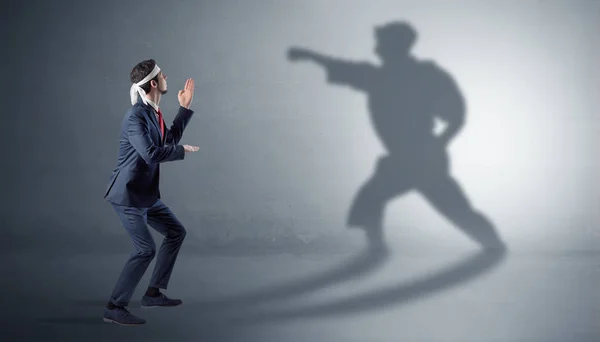 Joven hombre de negocios luchando con su sombra — Foto de Stock