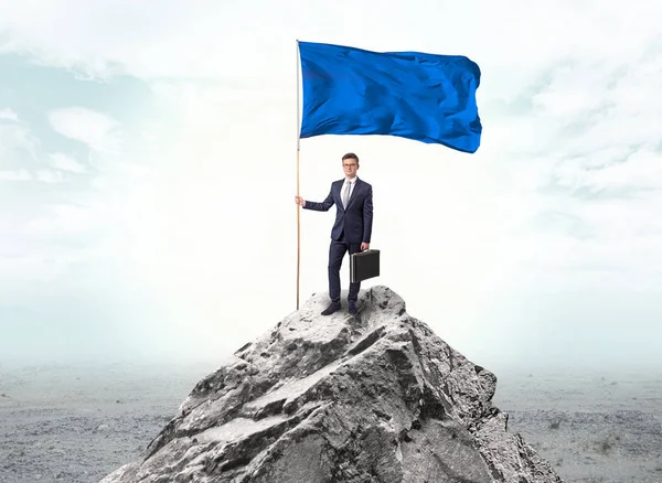 Empresario en la cima de una bandera de la montaña — Foto de Stock