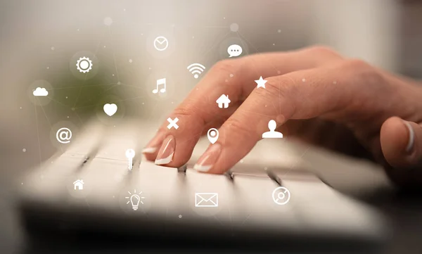 Hand typing on keyboard with application icons around — Stock Photo, Image