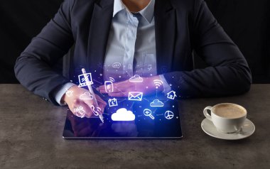 Yukarıdaki uygulama simgeleriyle tablet üzerinde çalışan iş kadın