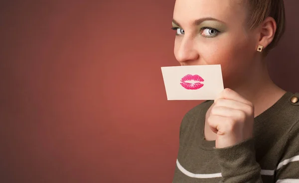 Persona sorridente con una carta davanti alla bocca — Foto Stock