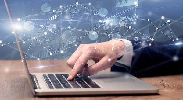 El laptop ile bağlantılı bir rapor ve grafikler çevresinde yazarak