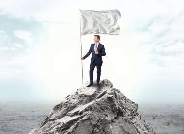 İşadamı üst tarafındaki bir bayrak tutan dağ
