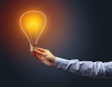 Koyu arkaplanda el ele tutuşan ampul