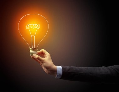 Koyu arkaplanda el ele tutuşan ampul