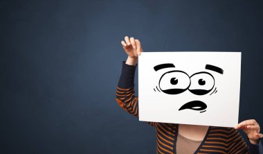 Yüzünün önünde komik ifade ile bir kağıt tutan kişi