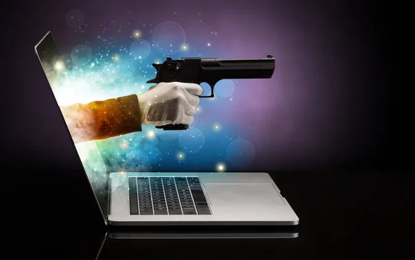 Ruka se zbraní vycházející z notebooku — Stock fotografie