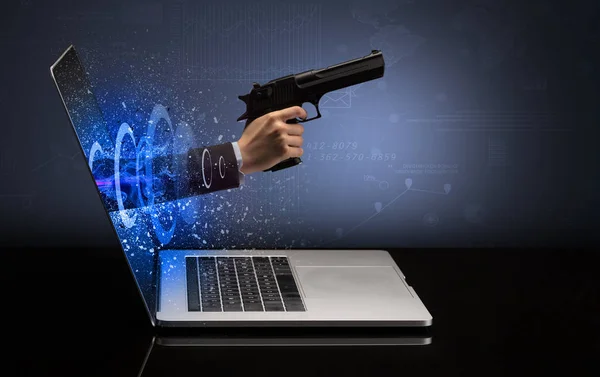 Main avec pistolet sortant d'un ordinateur portable — Photo