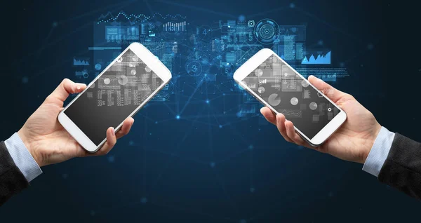 Dos manos sosteniendo teléfonos inteligentes para sincronizar datos comerciales —  Fotos de Stock