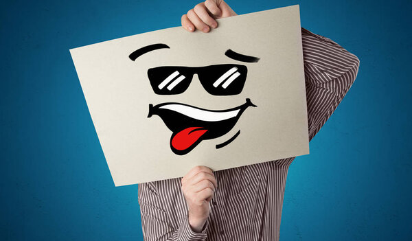 Person holding a paper with cool emoticon face