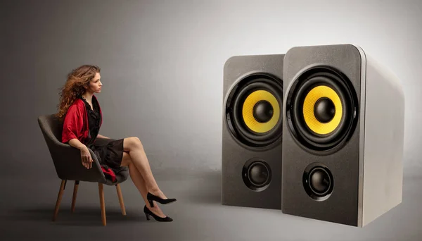 Young lady listening to big loudspeakers — Stock Photo, Image