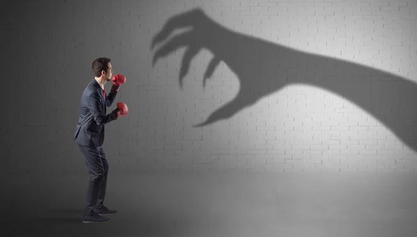 Бизнесмен борется со страшной тенью на руке — стоковое фото