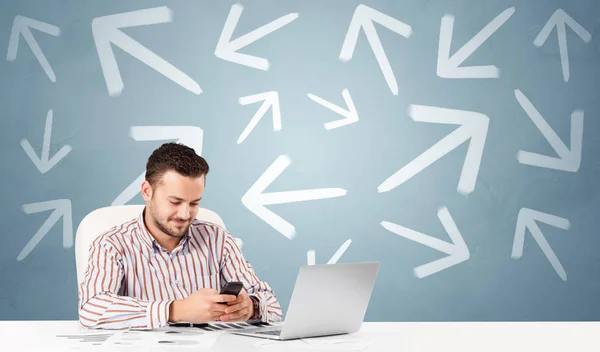 Business person sitting at desk with direction concept — Stock Photo, Image