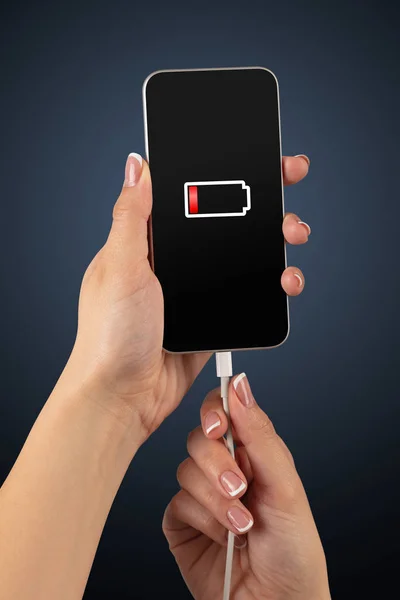 Ręka ładowanie telefonu przy niskim poziomie naładowania baterii — Zdjęcie stockowe