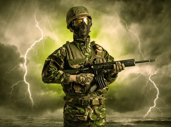 Soldado armado parado en un clima oscuro — Foto de Stock