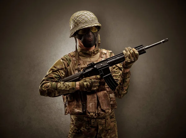 Soldat i et mørkt rom med armer. – stockfoto
