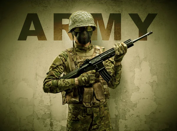 Armed soldier with damaged wall background — Stock Photo, Image