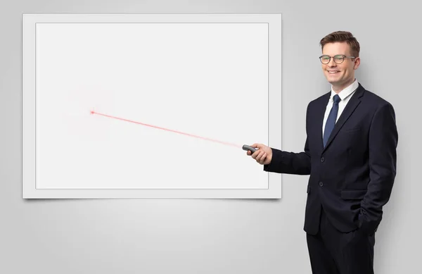 Businessman with laser pointer and copyspace white blackboard — Stock Photo, Image