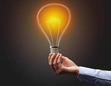 Koyu arkaplanda el ele tutuşan ampul