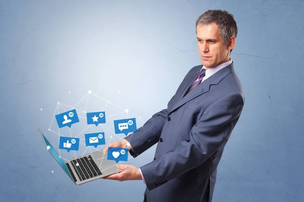 Чоловік тримає ноутбук із сповіщеннями у соціальних мережах — стокове фото