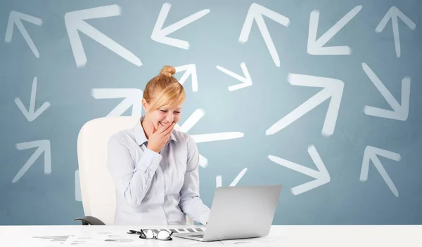 Business person sitting at desk with direction concept — Stock Photo, Image