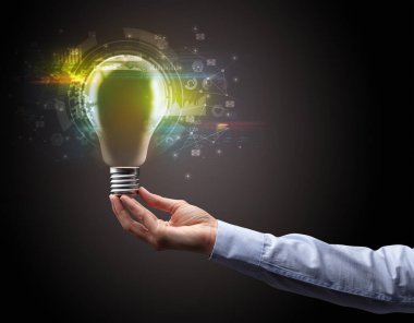 Koyu arkaplanda el ele tutuşan ampul