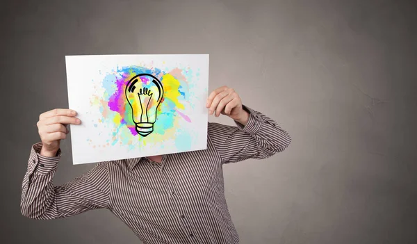 Osoba, která drží papír s konceptem barevné žárovky — Stock fotografie