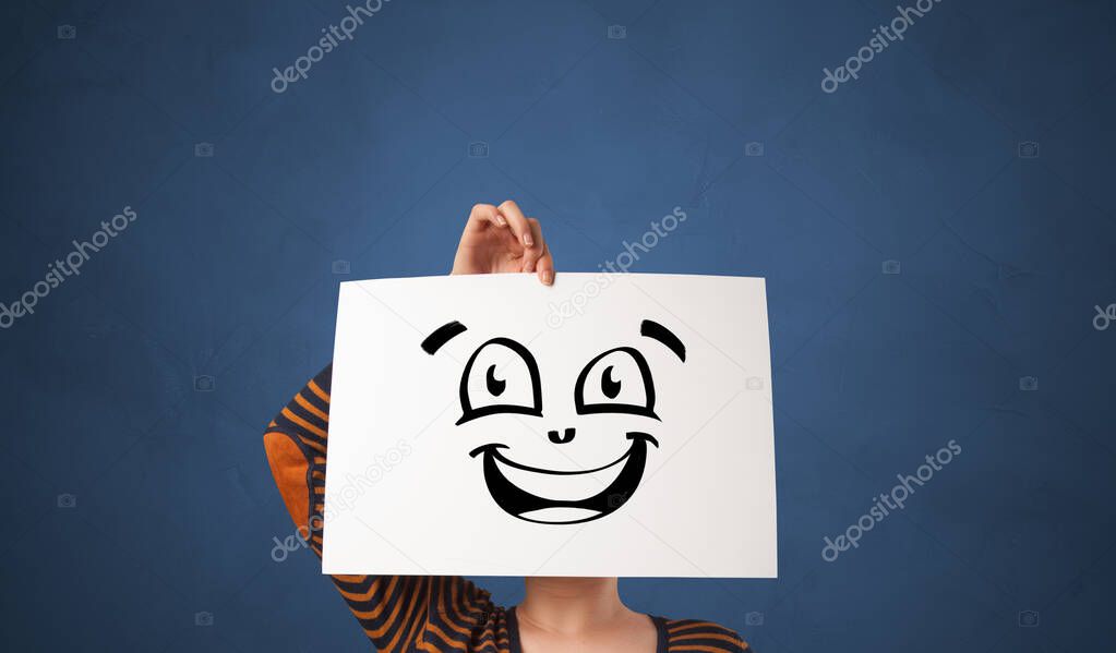 Person holding a paper in front of his face with doodle emoticon