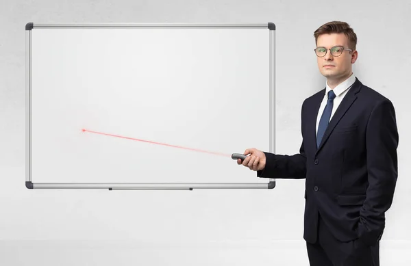 Businessman with laser pointer and copyspace white blackboard — Stock Photo, Image