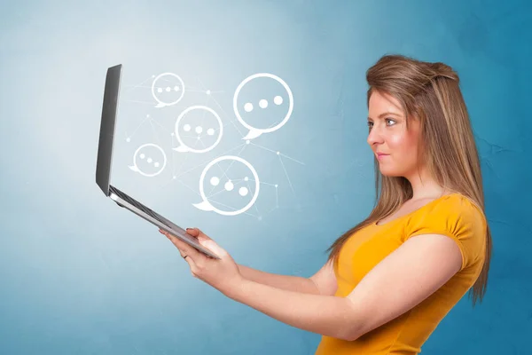 Woman holding laptop with speech bubbles — Stock Photo, Image