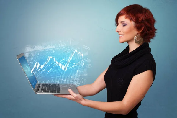 Kvinna som håller laptop med finansiella begrepp — Stockfoto
