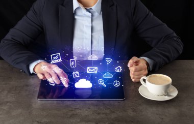 Yukarıdaki uygulama simgeleriyle tablet üzerinde çalışan iş kadın