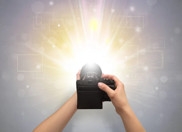 Mão tirando foto com o conceito de flash brilhante — Fotografia de Stock