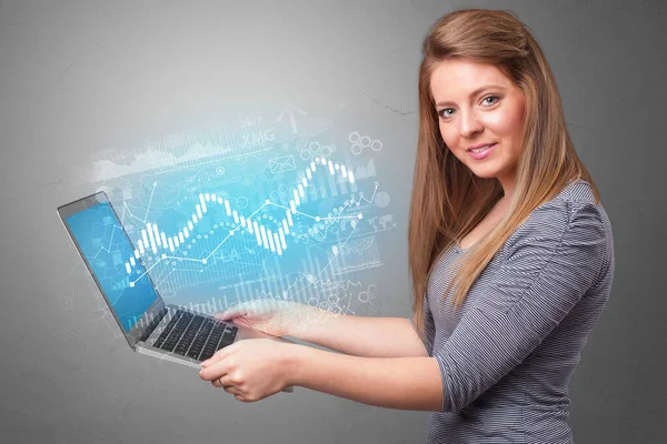 Kvinna som håller laptop med finansiella begrepp — Stockfoto