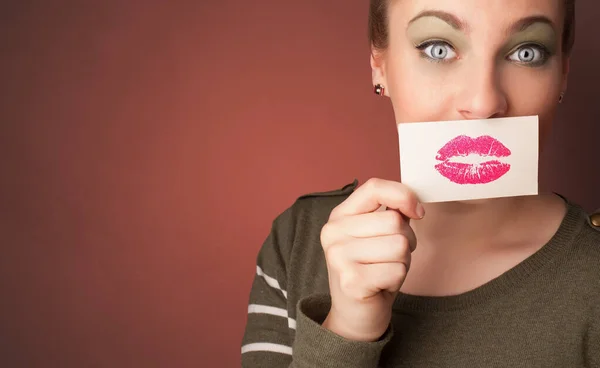 Persona sorridente con una carta davanti alla bocca — Foto Stock