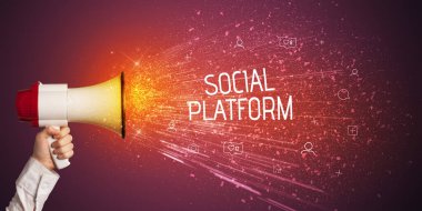 Genç bir kadın hoparlöre bağırıyor.