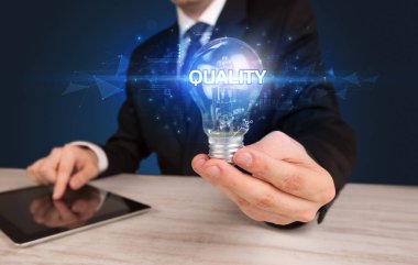 Elinde ampul tutan bir iş adamı.