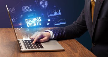 Dizüstü bilgisayar ve iş konsepti üzerinde çalışan iş adamı