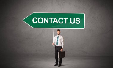 Gündelik trafik levhasındaki genç iş adamı.