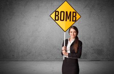 Genç iş adamı yol tabelasını tutuyor.