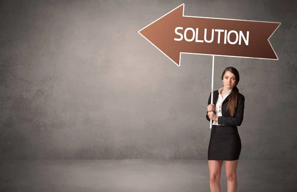 Young business person in casual holding road sign — Stock Photo, Image