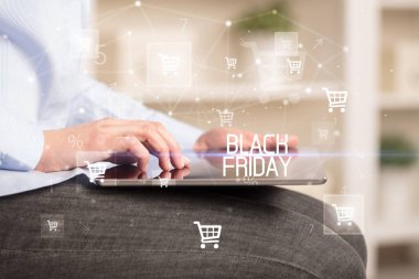 Genç adam tabletle alışveriş yapıyor.