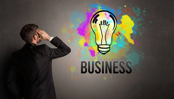 Hombre de negocios dibujo bombilla de colores — Foto de Stock