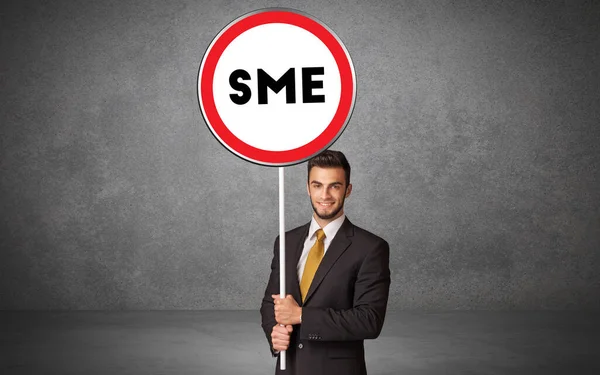 Young business person holdig traffic sign — Stock Photo, Image