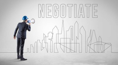 Kasketli bir iş adamı elinde planlar tutuyor