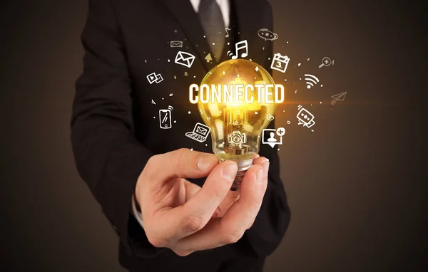 Businessman holding a light bulb, social media concept — Stock Photo, Image