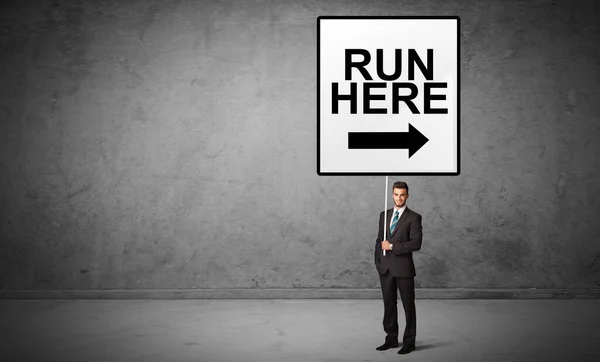 Business person holding a traffic sign — Stock Photo, Image