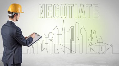 Kasketli bir iş adamı elinde planlar tutuyor